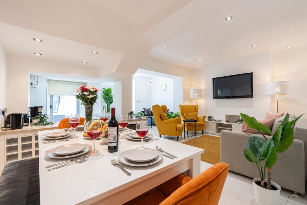 a kitchen and living room with a table with wine glasses at Stay Kensington & Chelsea in London