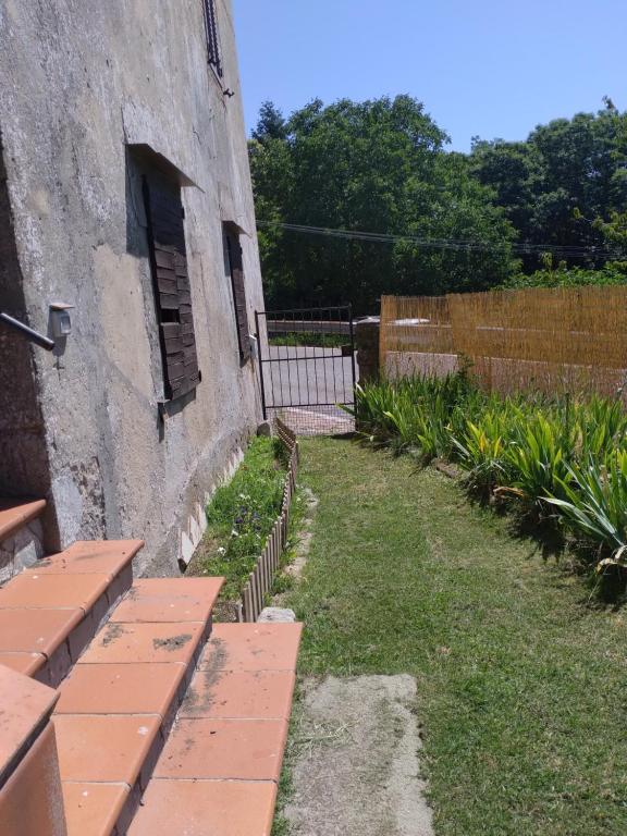 ein Steingebäude mit einem Hof mit einem Zaun in der Unterkunft Casa di montagna con spazio all'aperto 