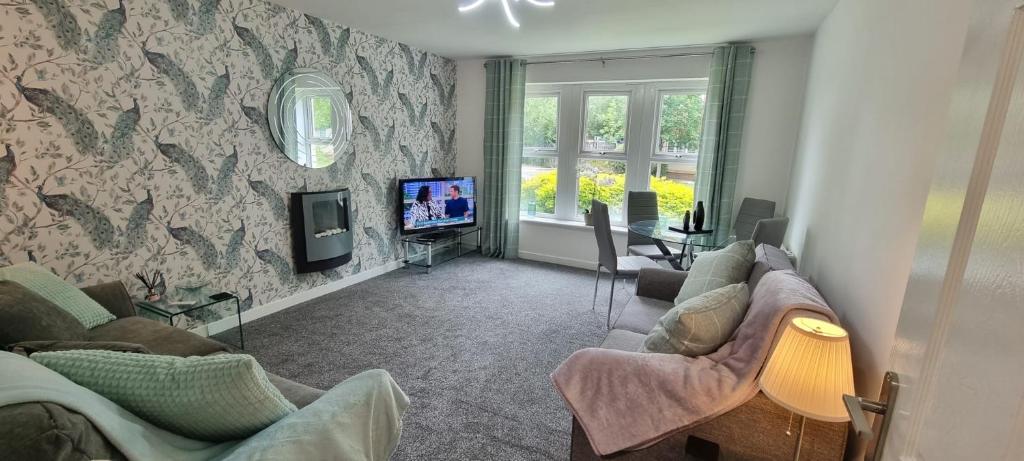 a living room with two couches and a tv at The Pennington Apartment & FREE Parking Next to Sports Village in Leigh
