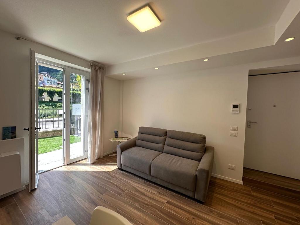 een woonkamer met een bank en een glazen schuifdeur bij San Pellegrino Suites in San Pellegrino Terme