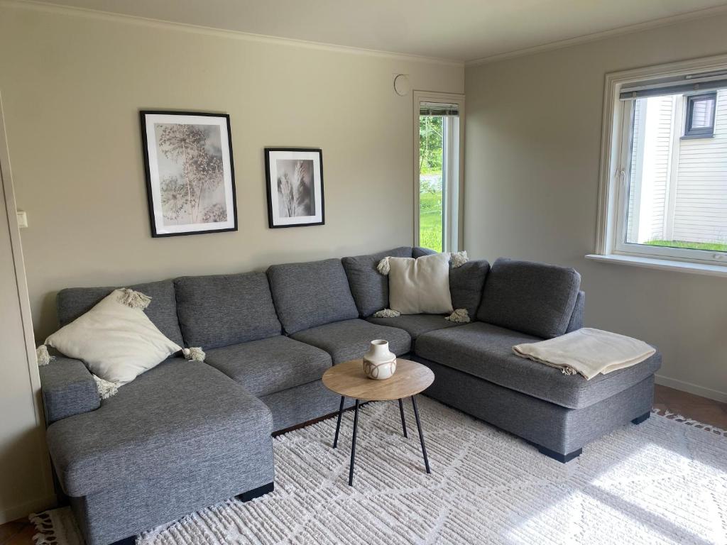 Sala de estar con sofá gris y mesa en WALO APARTMENTS Tromsø - Alfheim 10 min walk to city centre en Tromsø