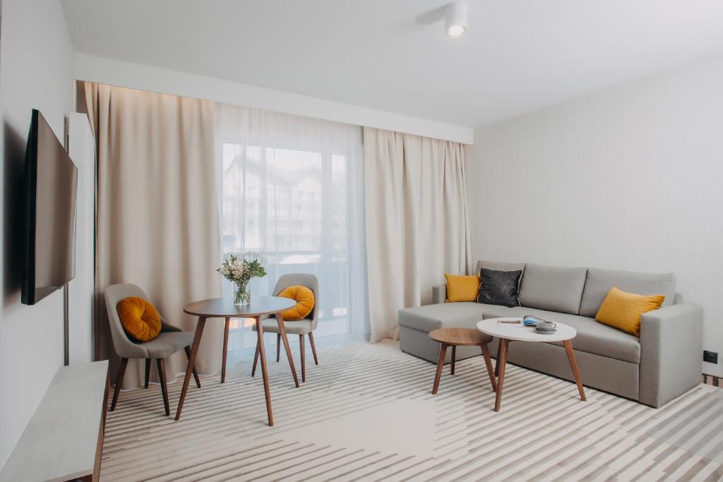 a living room with a couch and a table and chairs at Elements Apartments in Świeradów-Zdrój