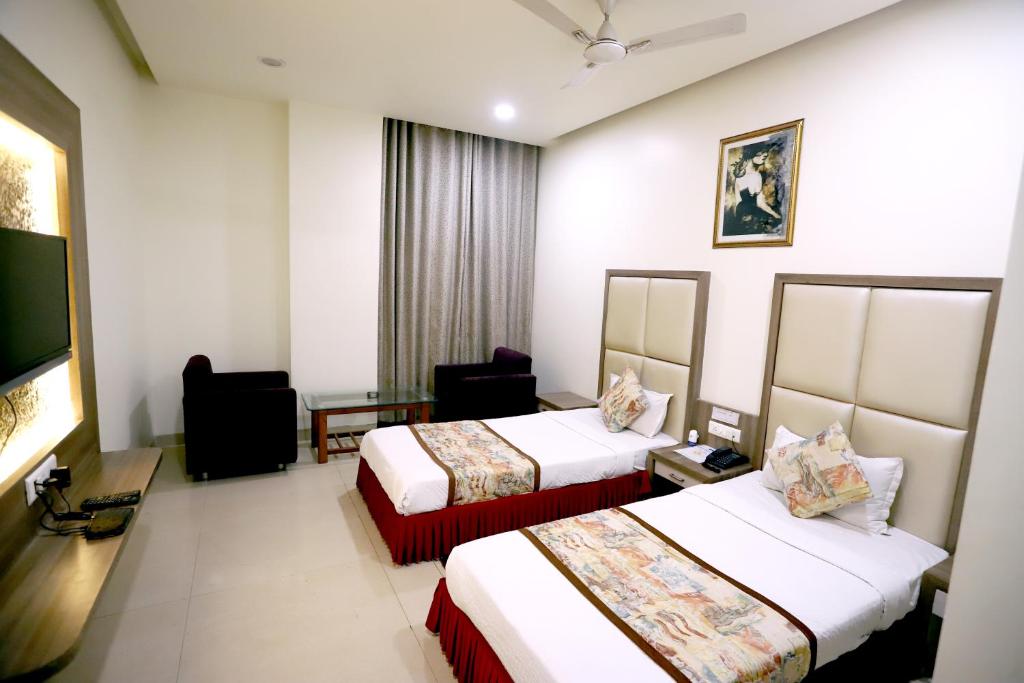 um quarto de hotel com duas camas e uma mesa em HOTEL BLUE PEARL em Bhopal