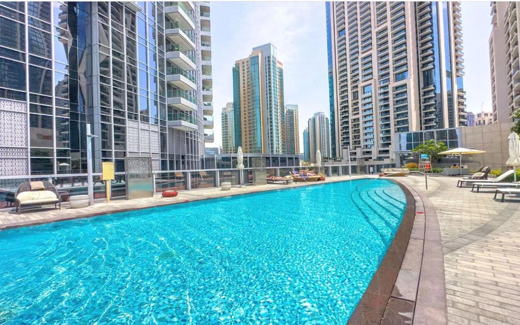 a swimming pool in a city with tall buildings at Delightful One-Bedroom in DownTown Dubai in Dubai