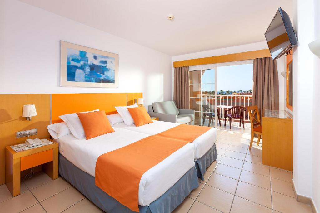 カレタ・デ・フステにあるHotel Chatur Costa Caletaの大きなベッドとバルコニーが備わるホテルルームです。