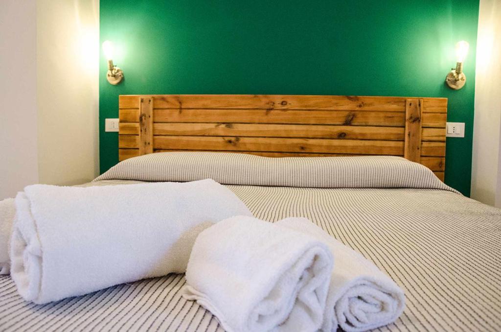 ein Schlafzimmer mit zwei weißen Handtüchern auf einem Bett in der Unterkunft Appartamenti La Baia del Raìs in Falcone