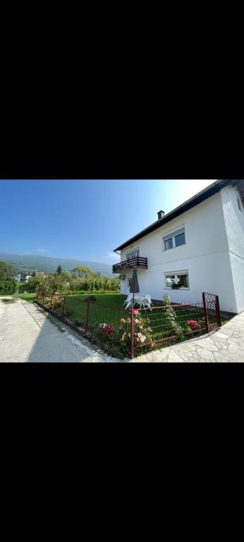 a white house with a fence next to a street at Villa Pliva Oasis in Jezero