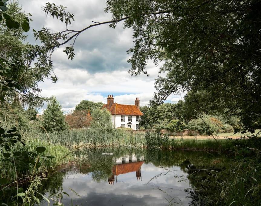 a white house in the middle of a lake at 5 Bed Farmhouse Suitable for Contractors Private Parking in Potter Street