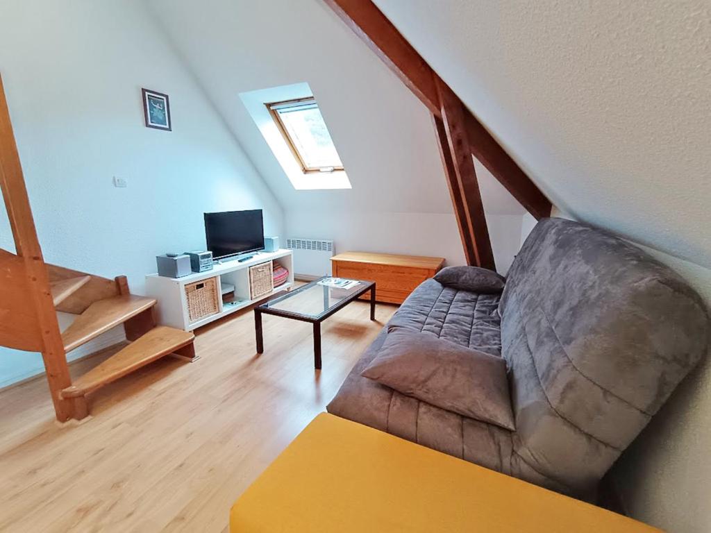 a living room with a couch and a tv at Chez Charlotte, T3 duplex, vue montagne, parking gratuit, 4 personnes in Luchon