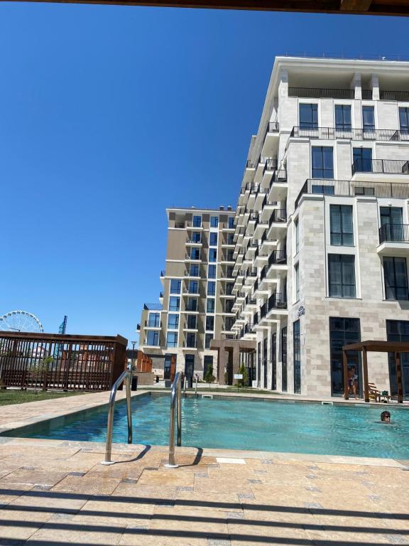 アクタウにあるAktau Riviera Актауの建物の前にプールがある建物