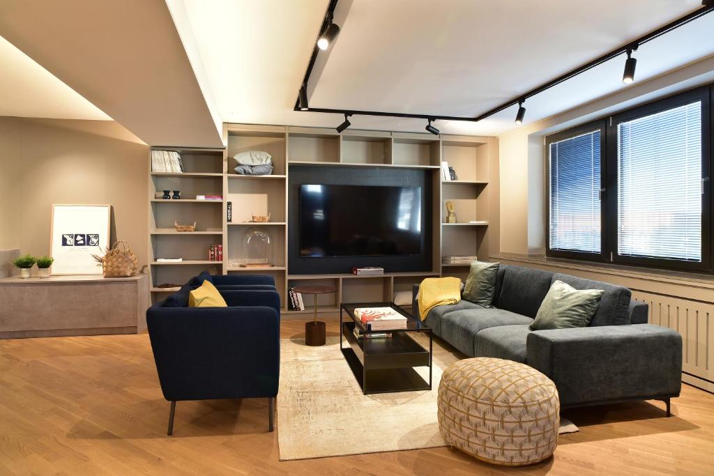 uma sala de estar com sofás e uma televisão de ecrã plano em SAXX Apartments Leipzig em Leipzig