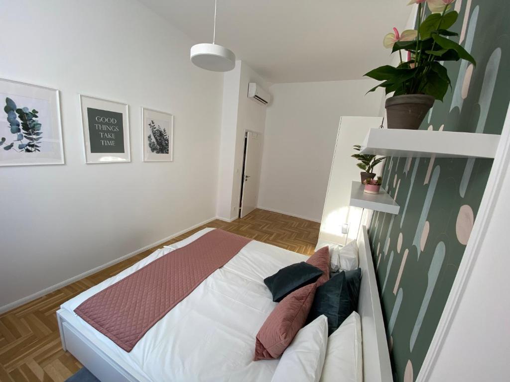 ein Schlafzimmer mit einem Bett und einer Pflanze an der Wand in der Unterkunft Birdie6 in Budapest