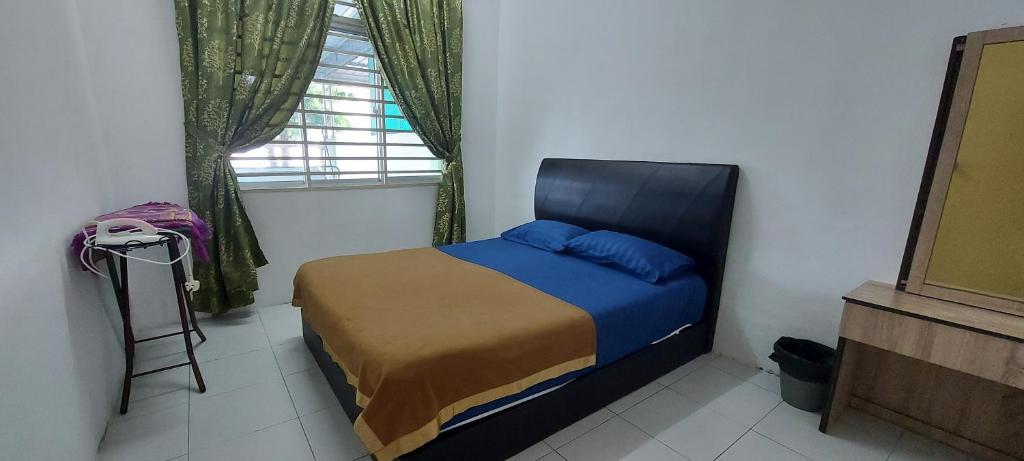 1 dormitorio con cama con sábanas azules y ventana en HDA Homestay Alor Setar Untuk Muslim Sahaja, en Alor Setar