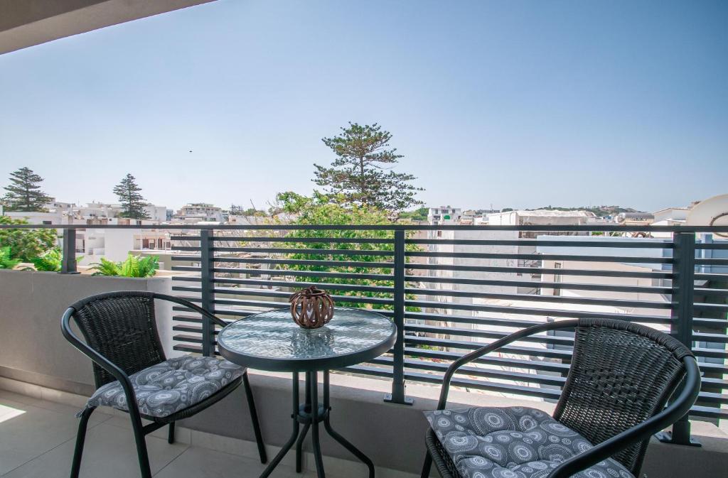 een klein tafeltje en twee stoelen op een balkon bij Anesis Town Apartments in Rhodos-stad