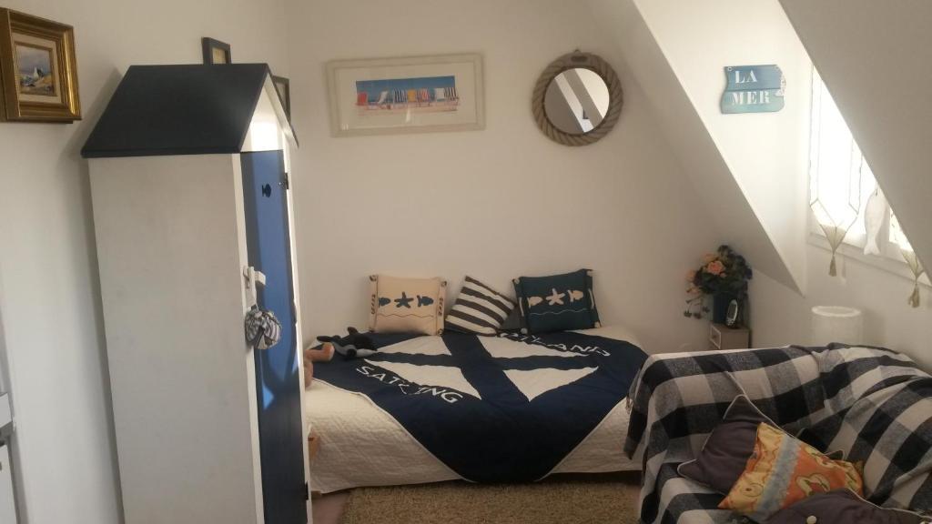une chambre avec un lit et un canapé dans l'établissement la plage location a la semaine samedi au samedi, à Villers-sur-Mer