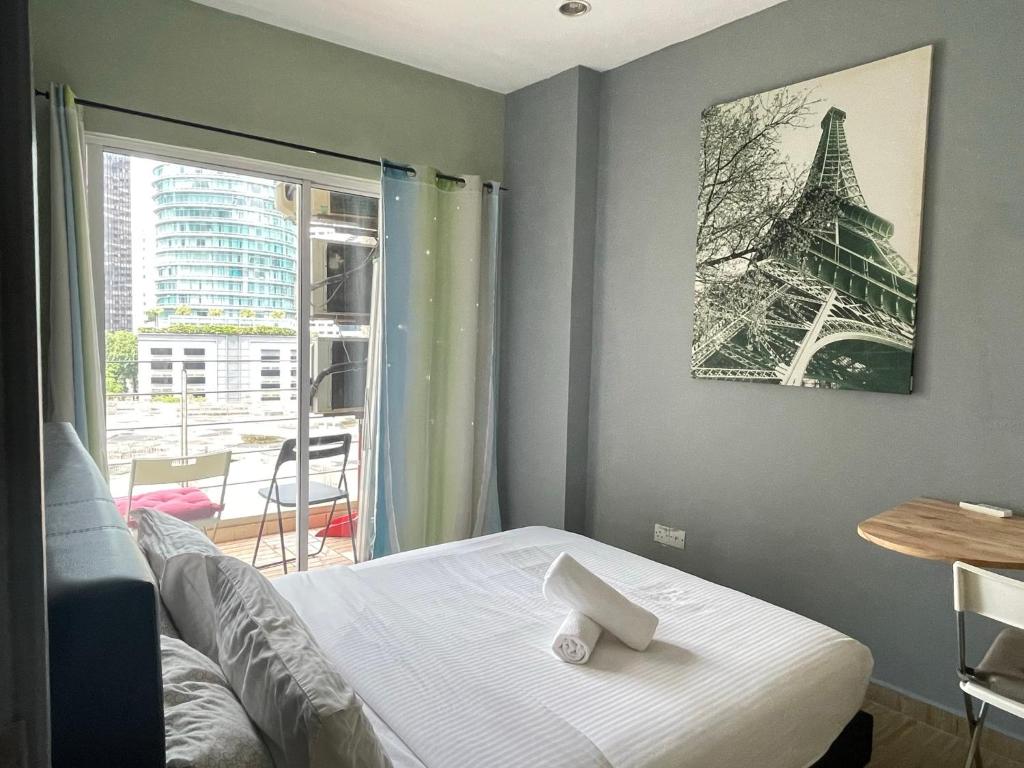 a room with a bed and a picture of the eiffel tower at Parkview Suite KLCC, Myhomey in Kuala Lumpur