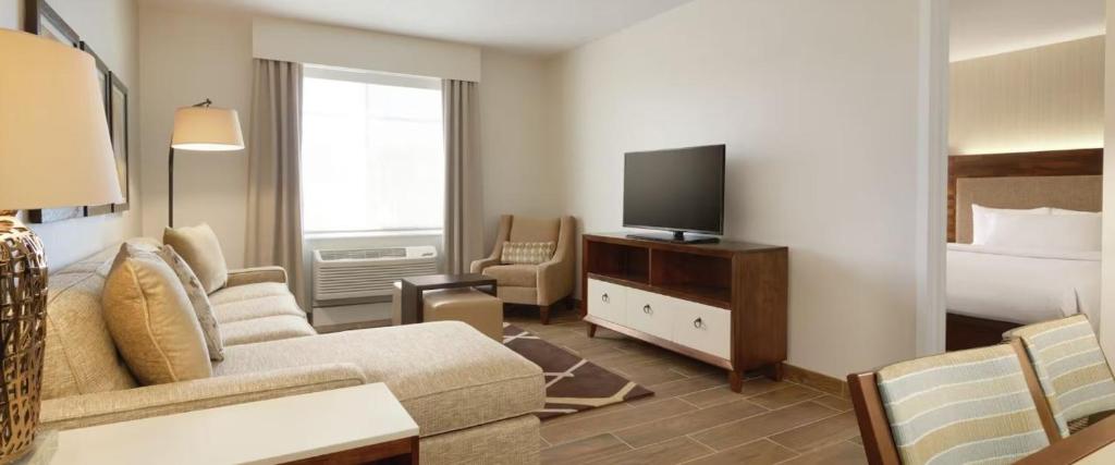Pokój hotelowy z kanapą, łóżkiem i telewizorem w obiekcie Homewood Suites By Hilton Missoula w mieście Missoula