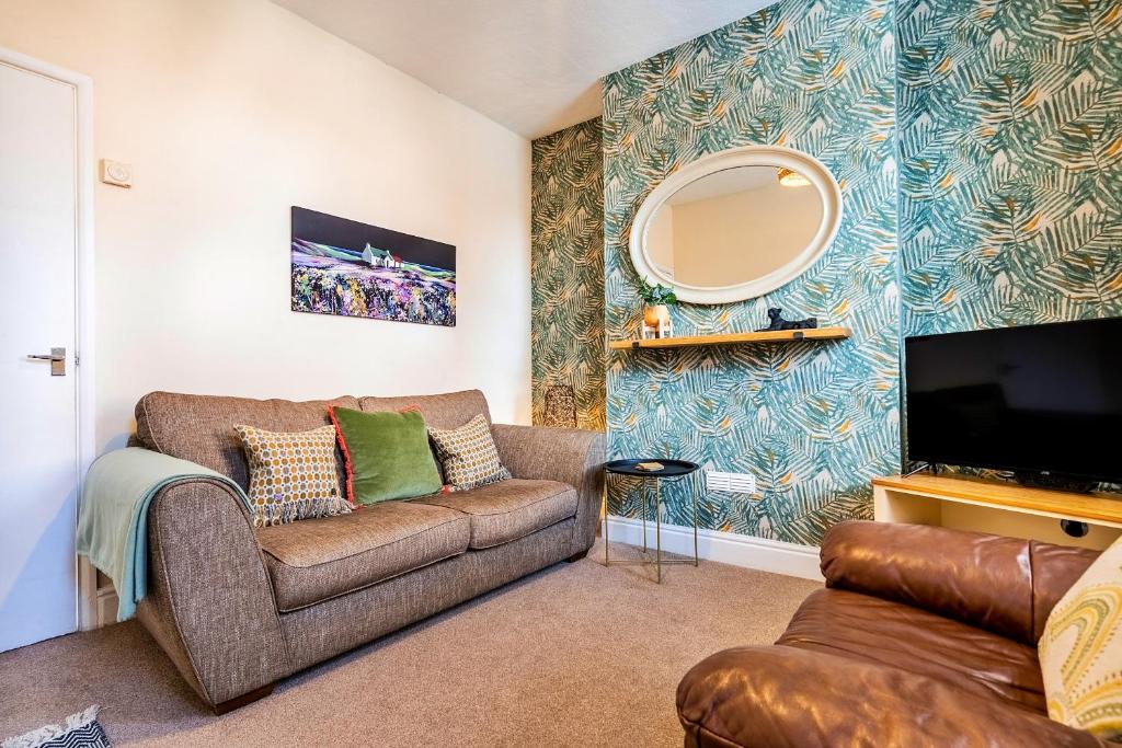 a living room with a couch and a tv at Finest Retreats - George Street in Grantham