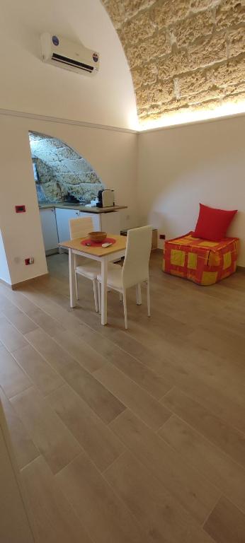 a room with a table and chairs and a bed at Le case di Roberto in Gioia del Colle