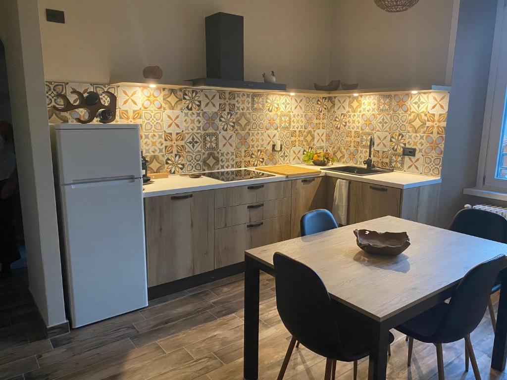 a kitchen with a table and a white refrigerator at Plaza Apartment in Cannobio