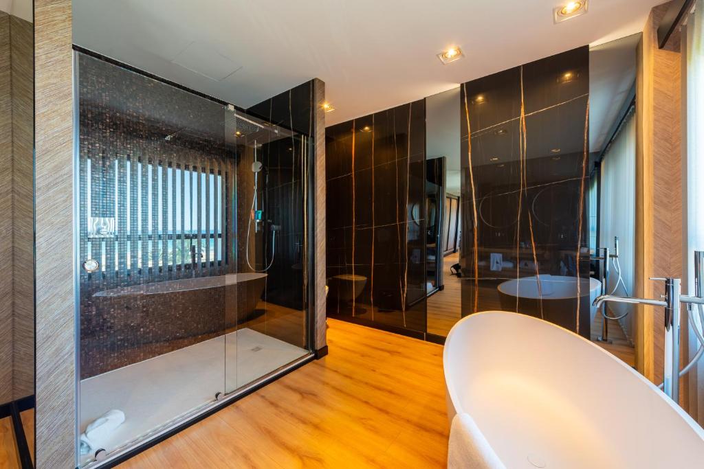 a bathroom with a glass shower and a white chair at Hotel Antonio II in Zahara de los Atunes