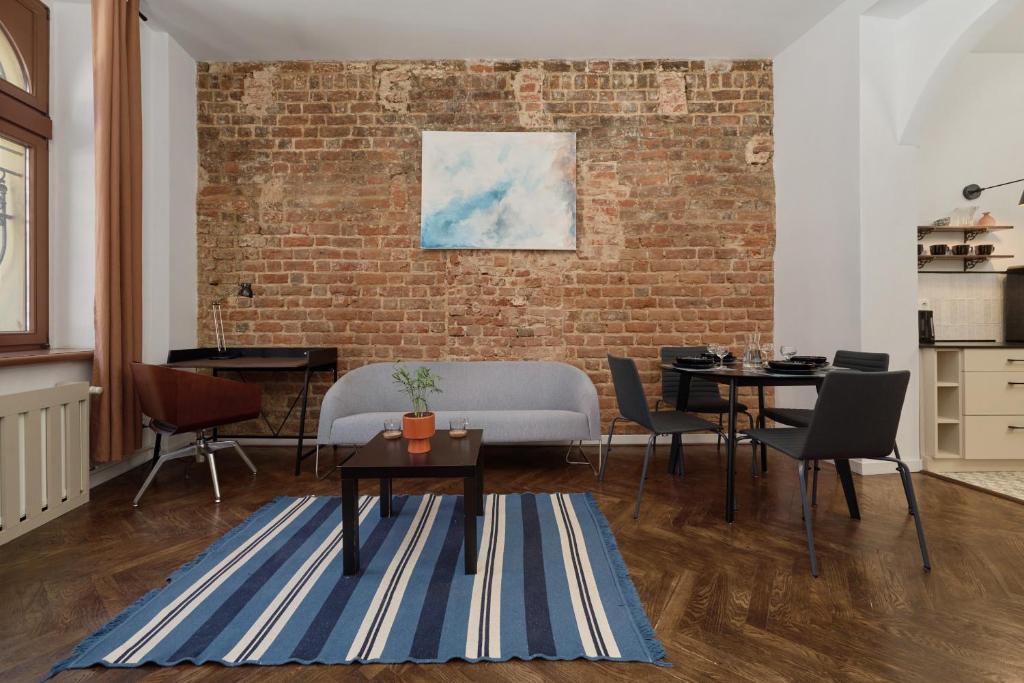 a living room with a couch and a brick wall at 350m to the Market Square - Św Antoniego Apartment by Renters in Wrocław
