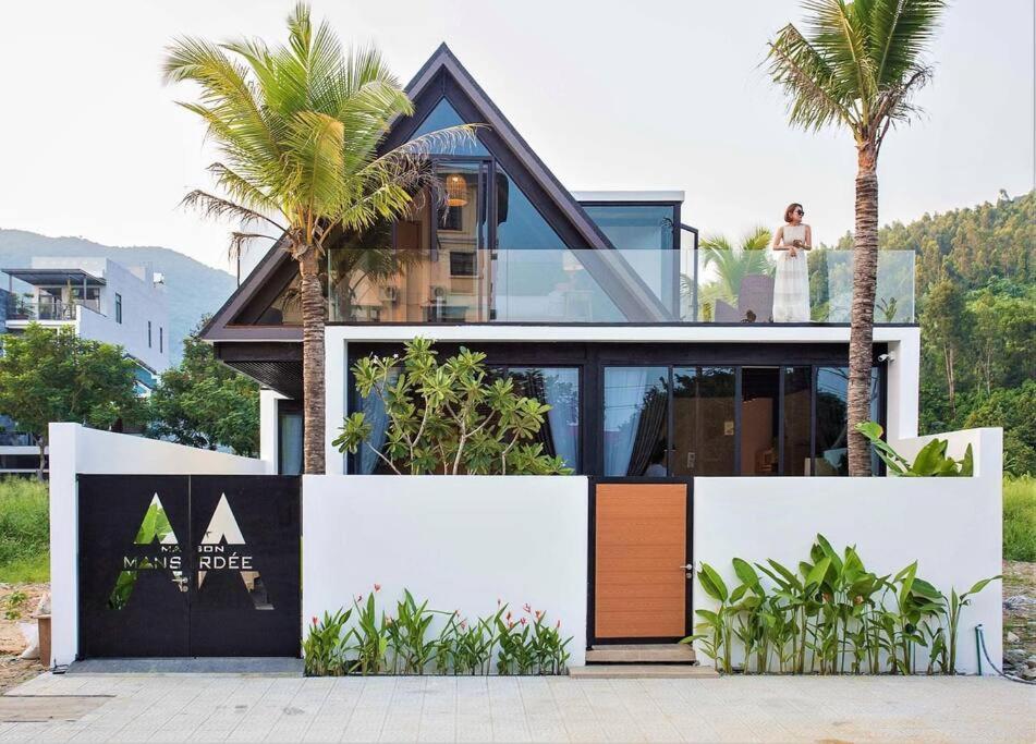 een huis met palmbomen ervoor bij Monkey Mountain Villa Retreat 1 in Da Nang