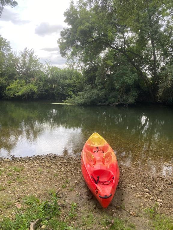 a red and yellow kayak sitting on the shore of a river at Loire Valley Llama Farm Stay in Lavernat