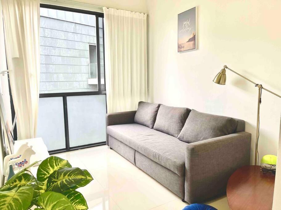 a living room with a couch and a large window at Centralize Stylish Loft Apartment Near MRT 市中心全景屋 in Singapore