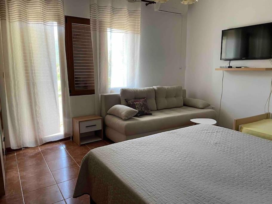 a bedroom with a bed and a couch and a tv at Comfortable apartment of 50 square meters in Herceg-Novi