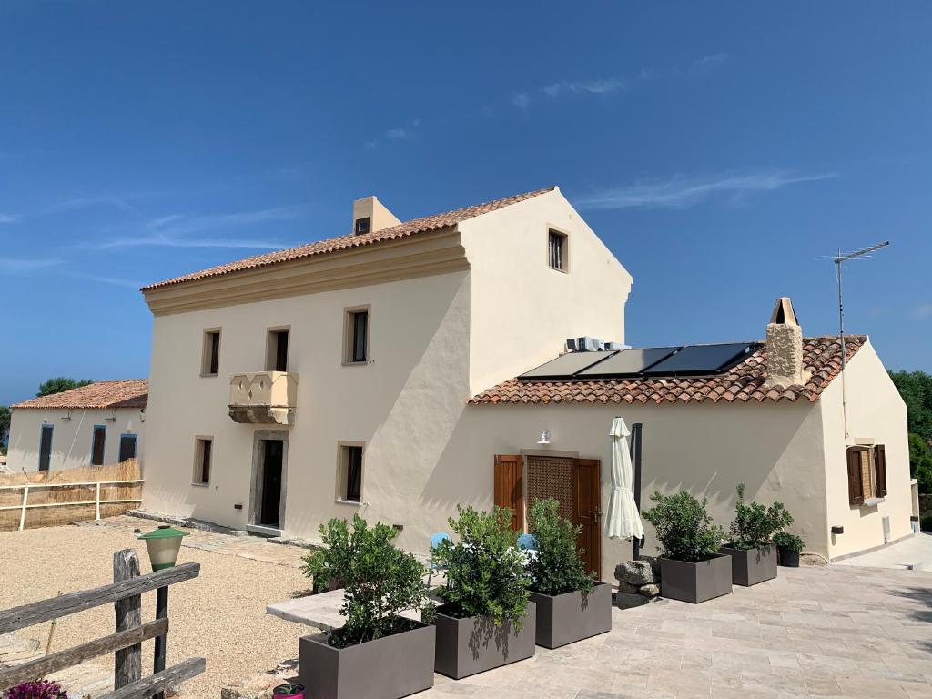 uma casa branca com painéis solares no telhado em Stazzu nuraghe Mannucciu em Rena Majore