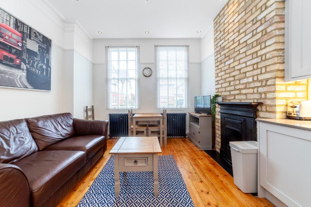 a living room with a couch and a table at Stylish 1 BDR apt wcommunal garden, Greenwich in London