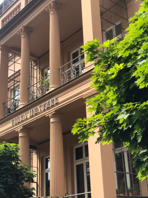 a building with columns and a sign on it at Hotel Villa Hentzel in Weimar