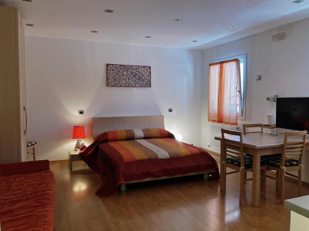 a bedroom with a bed and a table and a desk at Residence Stefania Cavasso Nuovo in Cavasso Nuovo