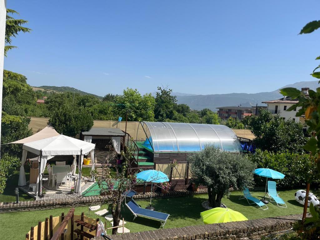 un parco con una casa e un parco giochi con ombrelloni di Casa vacanze villa Lido- Pangrazi Alessandra a L'Aquila