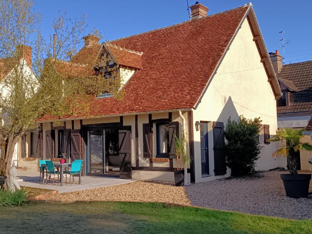 une maison avec une table et des chaises dans la cour dans l'établissement Séjour cosy entre Beauval et Center Parc, à Selles-sur-Cher