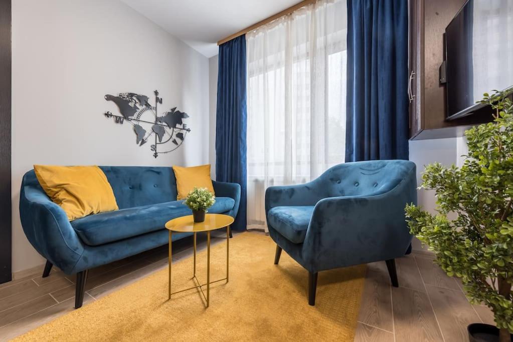 a living room with a blue couch and two chairs at Stylish apartment on Bregalnitsa str in Varna City