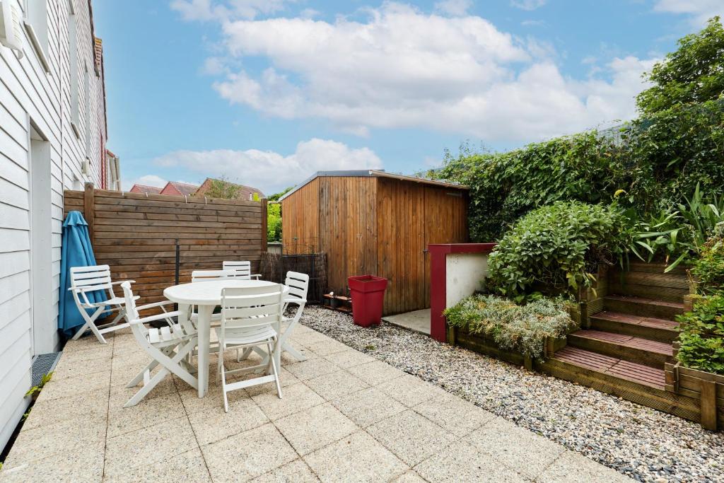 a patio with a table and chairs and a fence at Les Rochambelles - Maison avec terrasse in Ifs