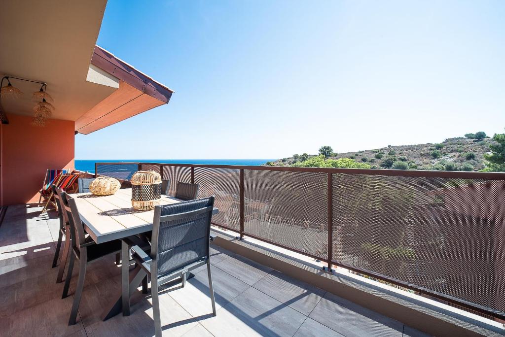 a balcony with a table and a view of the ocean at L'Escale de Collioure - Climatisé, parking privé sécurisé, vue mer in Collioure