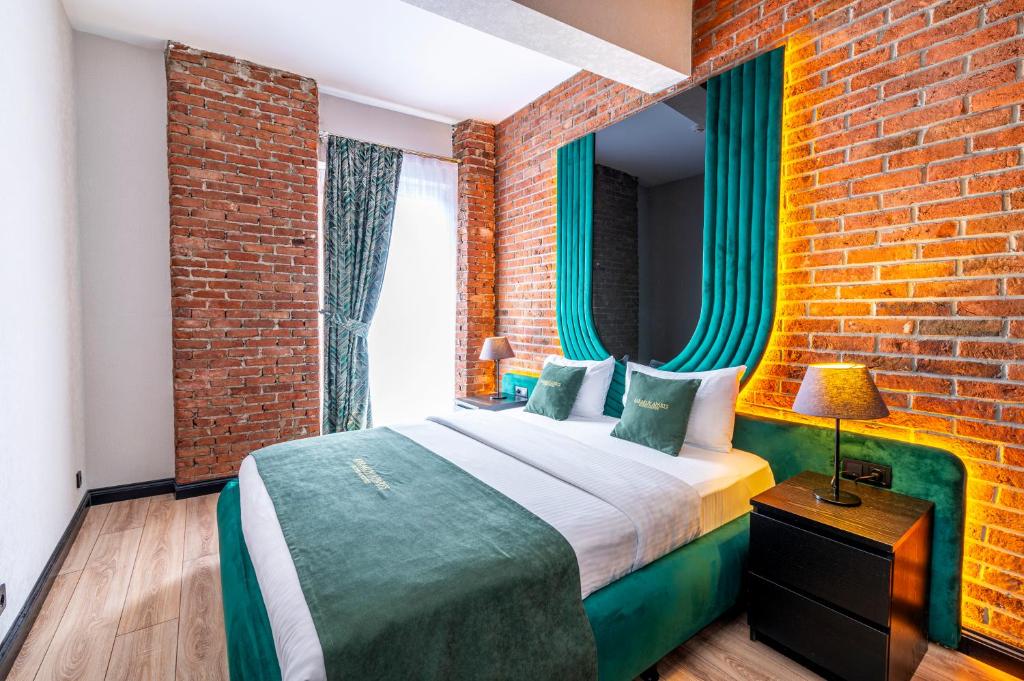 イスタンブールにあるカラキョイ アパーツ ホテル スペシャル カテゴリーのレンガの壁、ベッド付きのベッドルーム1室