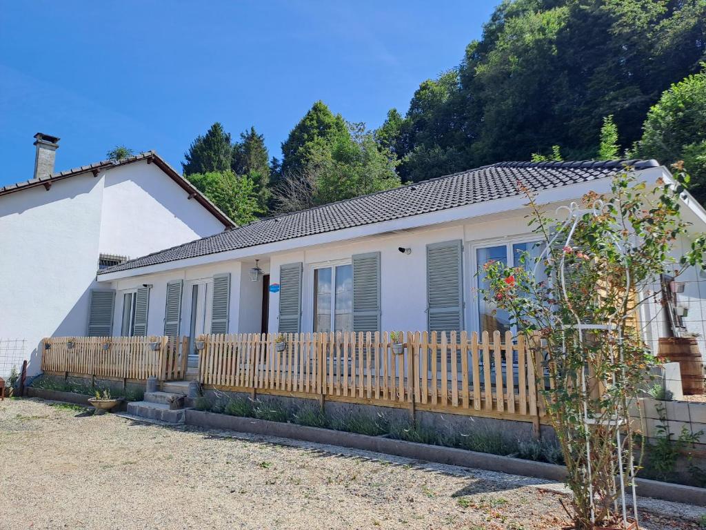 ein Haus mit einem Holzzaun davor in der Unterkunft Gites Puy Mary et Puy Griou in Saint-Cernin