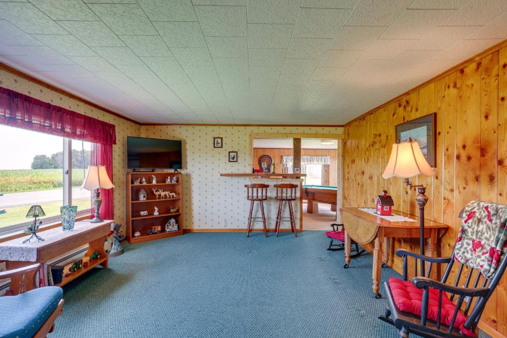 uma sala de estar com paredes de madeira e uma mesa e cadeiras em Penn Yan Vacation Rental Near Seneca and Keuka Lakes em Penn Yan