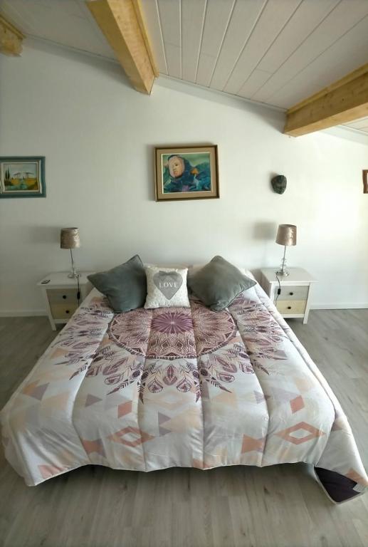 a bedroom with a large bed with two night stands at Alaric Lodge: gîte champêtre avec parking privé. in Comigne