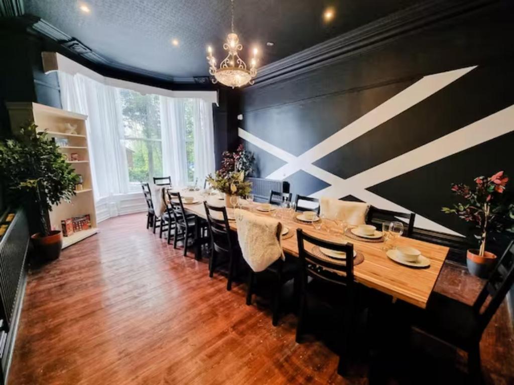 a large dining room with a long table and chairs at Sleeps 20 Stunning Ashton Mansion in Ashton under Lyne