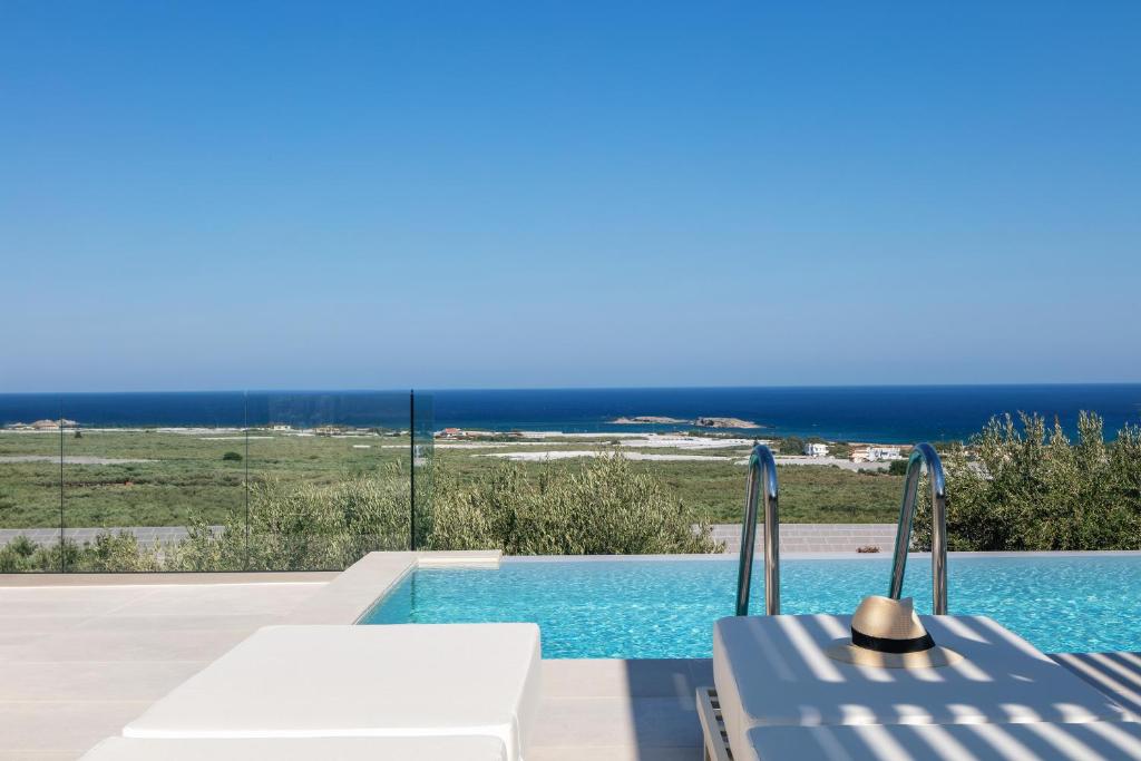 a swimming pool with a view of the ocean at Petras Luxury Villas in Falasarna