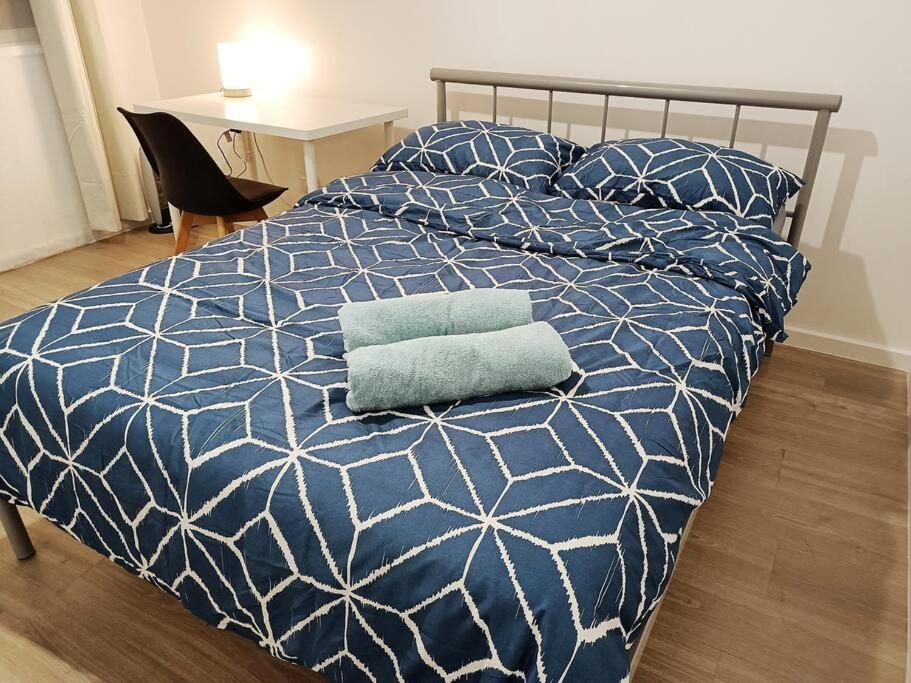 łóżko z niebiesko-białą kołdrą i poduszką w obiekcie PROMO 2-Bedroom Villa Next to Train Station, FREE PARKING w Melbourne