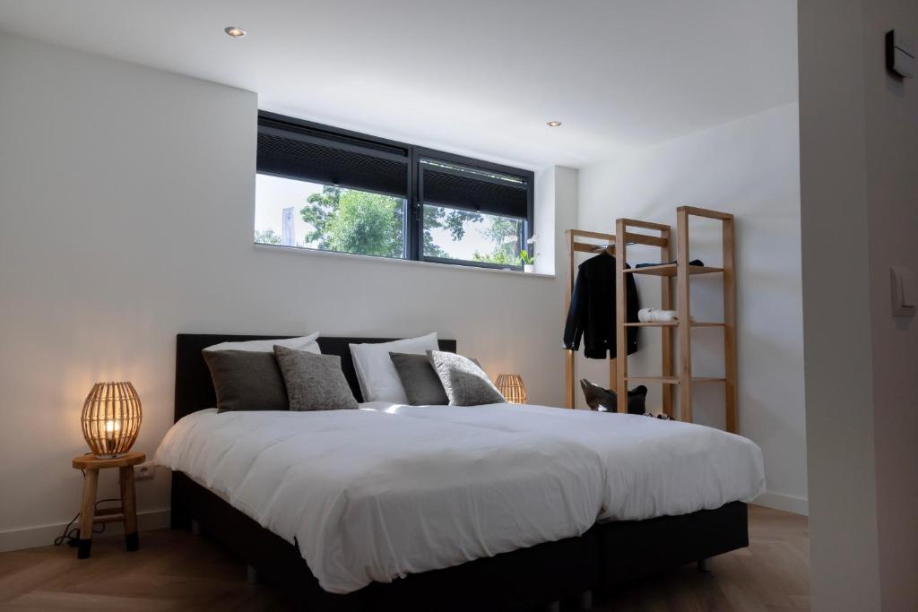 a bedroom with a large bed with a window at Villa Nautica Kortgene in Kortgene