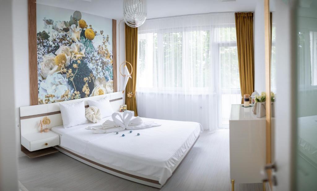 a bedroom with a white bed with a painting on the wall at A&K KOZY ART Studio 2 in Varna City