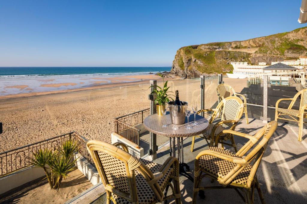 a patio with a table and chairs on the beach at Tolcarne Beach Apartments in Newquay