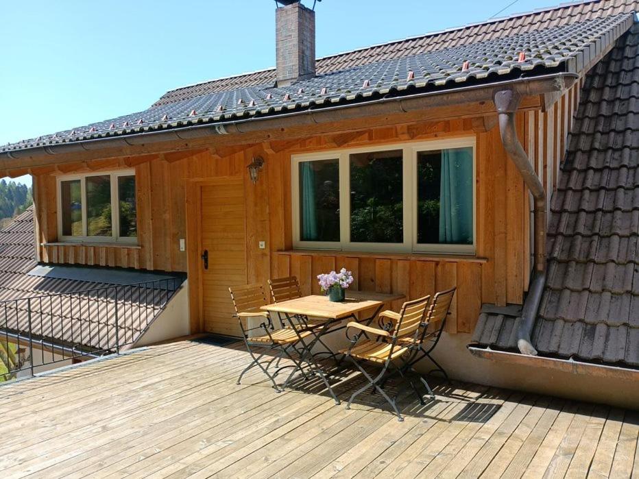 una terraza de madera con mesa y sillas en una casa en Zum Eichbühl, en St. Blasien